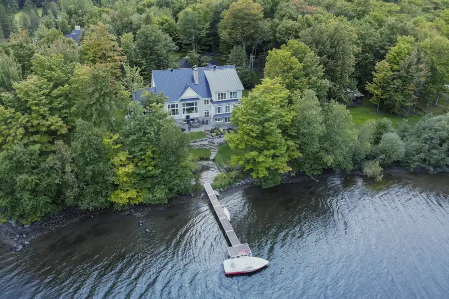 Vue aérienne d'une propriété riveraine avec quai sur la rivière