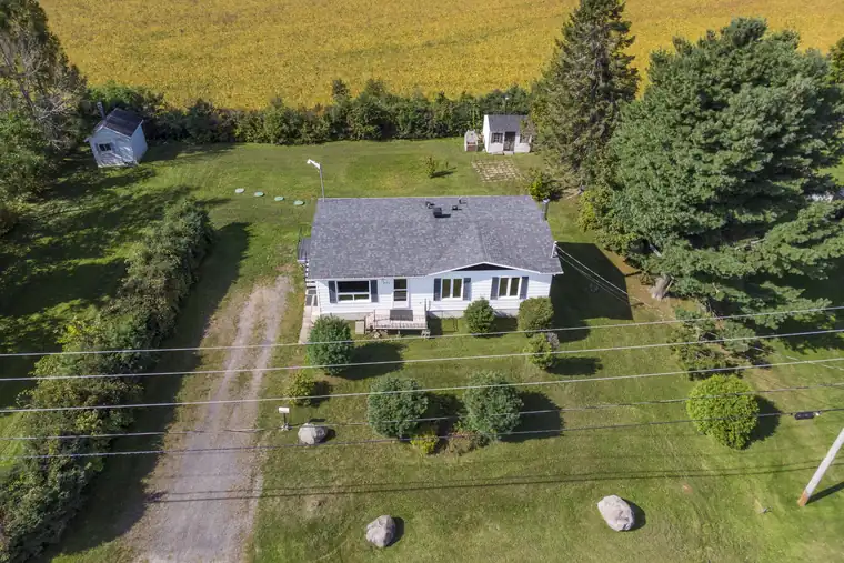 Vue aérienne d'une maison de campagne bordée de champs cultivés